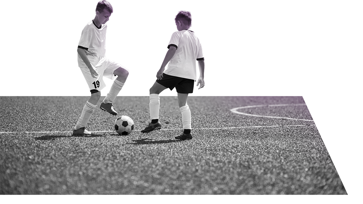 two youth athletes playing soccer